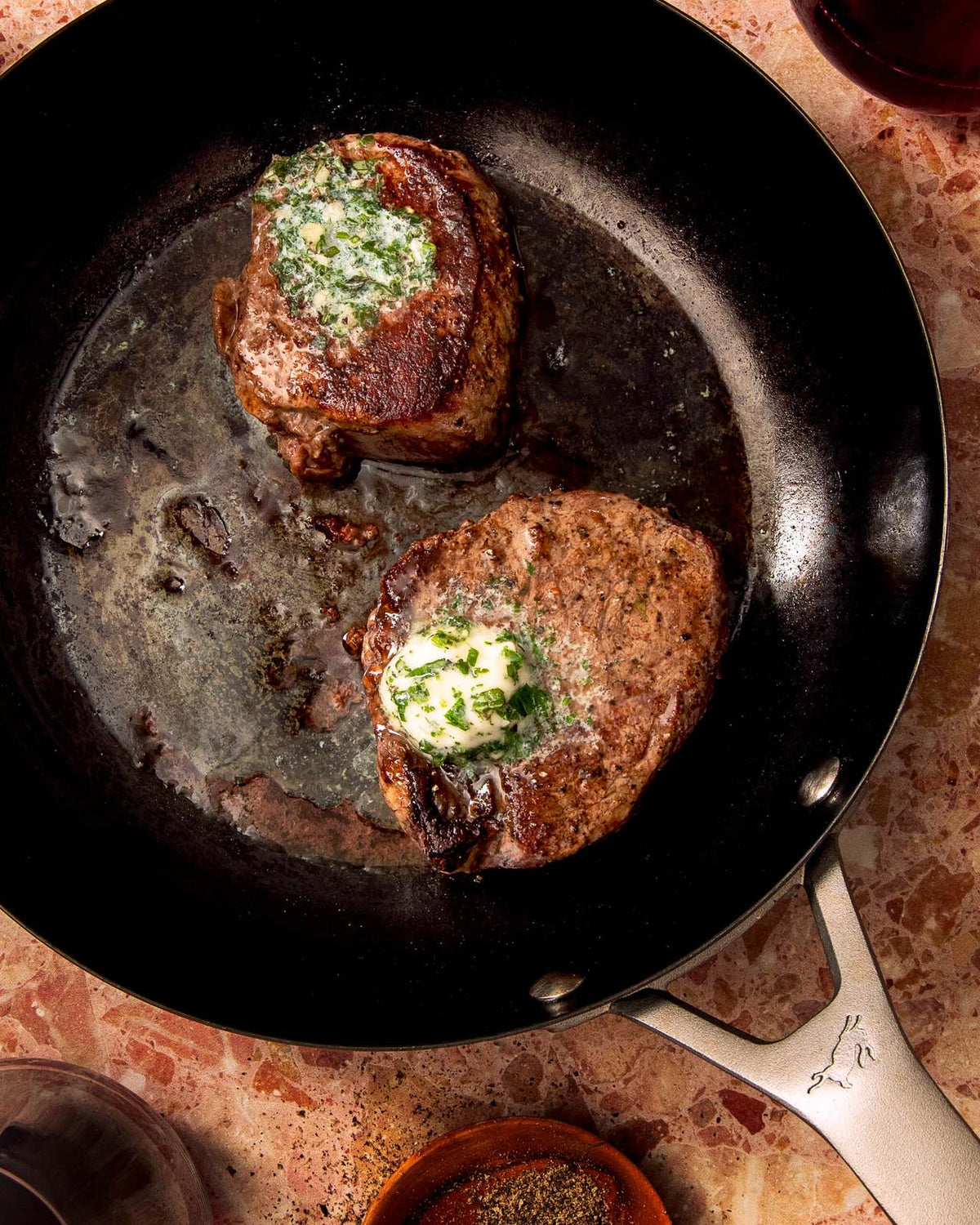 Steak being seared in a pan for a home cooking guide