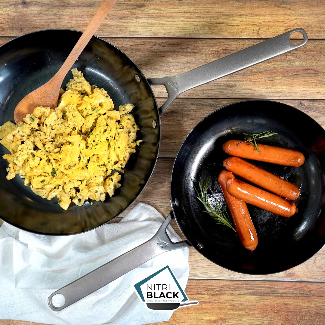 Nitrided carbon steel pans with food on a wooden surface