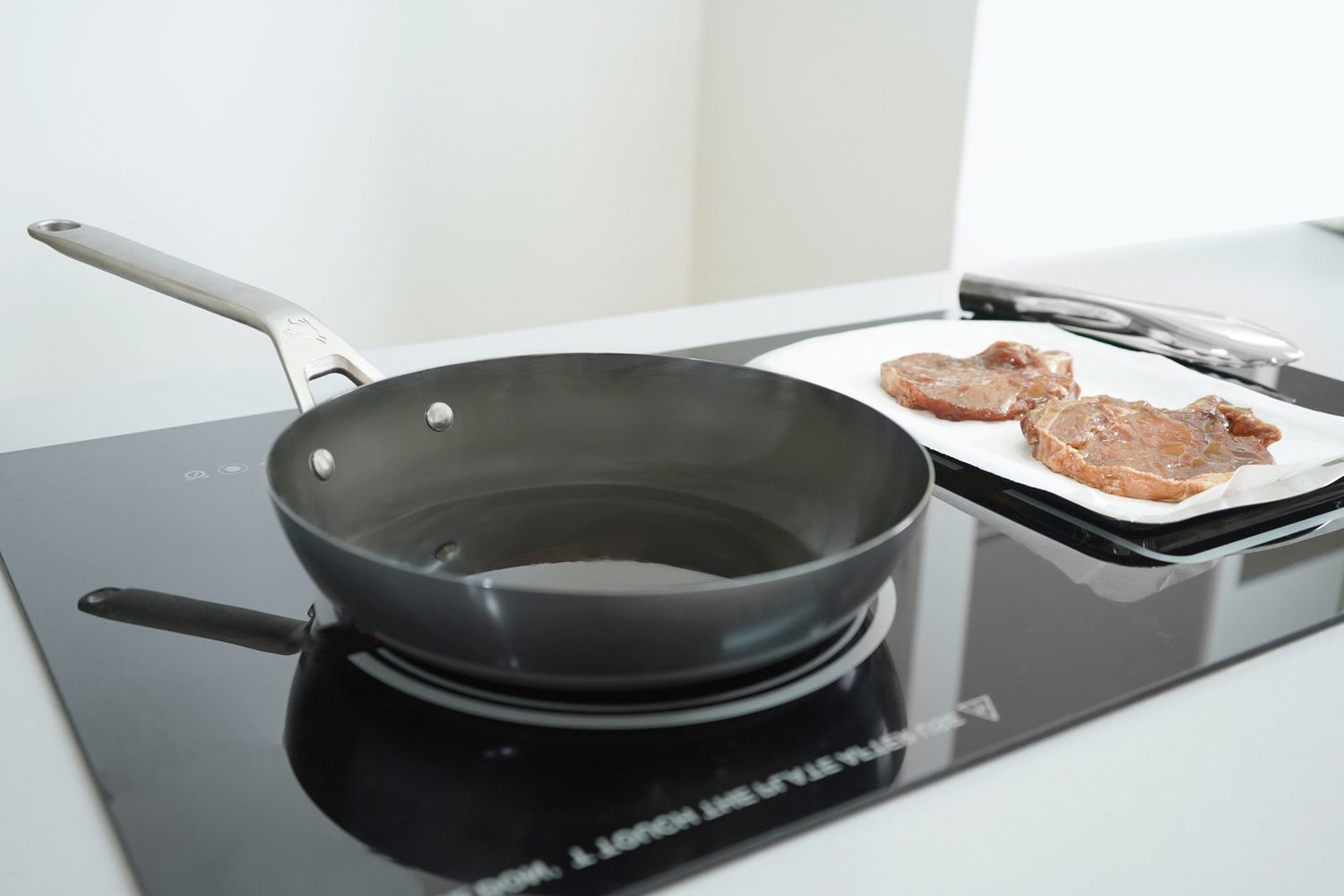 Carbon steel cookware being used on a kitchen hob