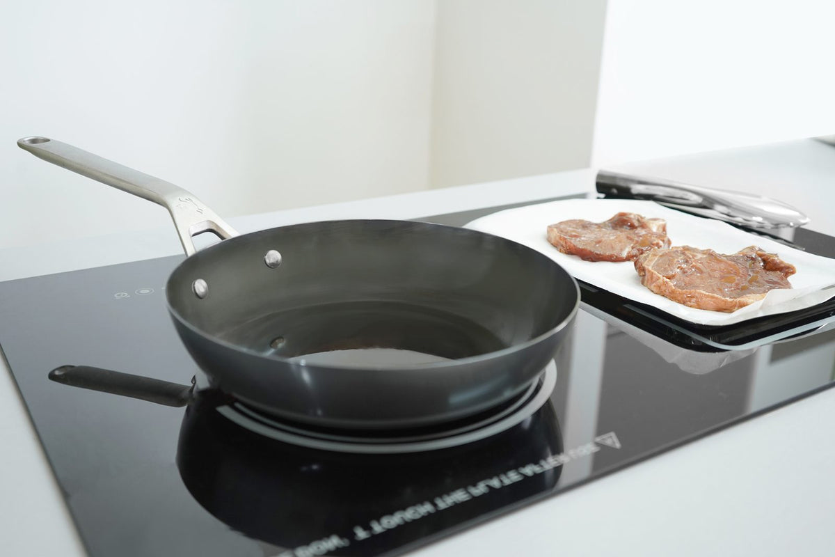 Carbon steel cookware being used on a kitchen hob